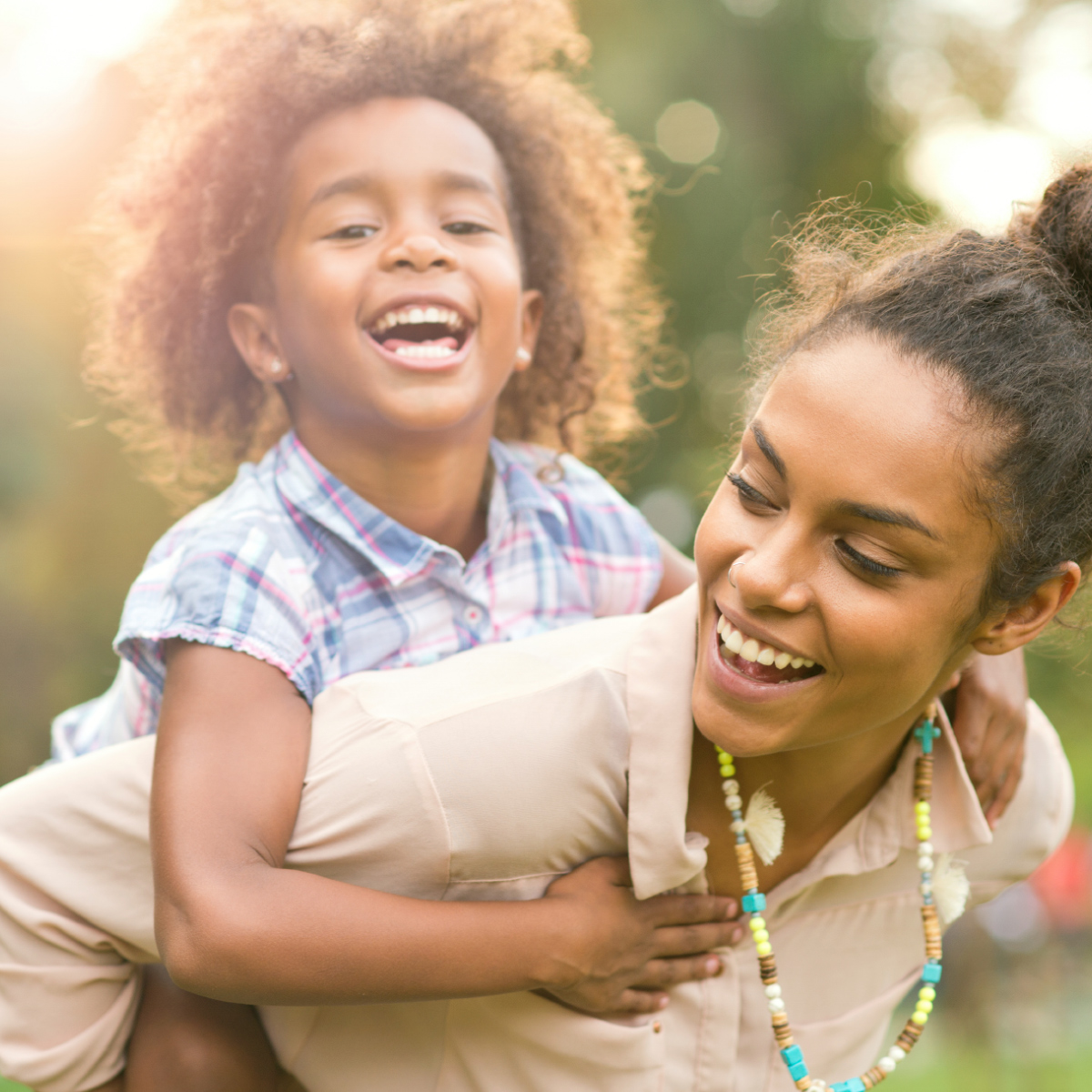 happy woman playing piggyback with smiling child